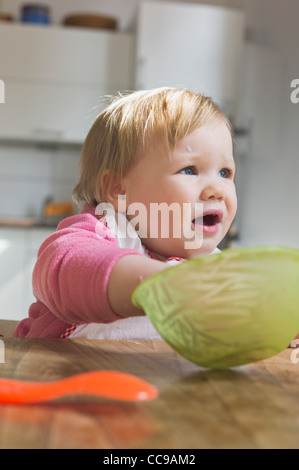 Baby girl mangiare dalla ciotola Foto Stock