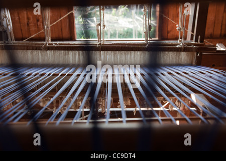 Close up di fiocco sul telaio nel laboratorio di tessitura in Birmania. Foto Stock