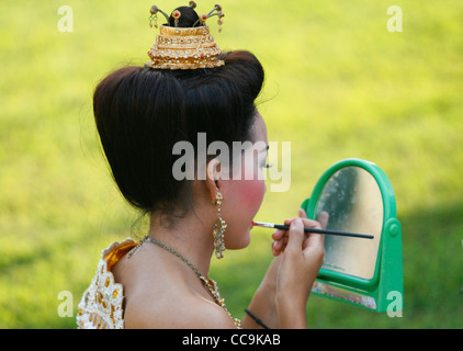 Una giovane ragazza di applicare il make-up prima che il Loi krathong celebrazioni. Sukhothai Historical Park, Thailandia. Foto Stock