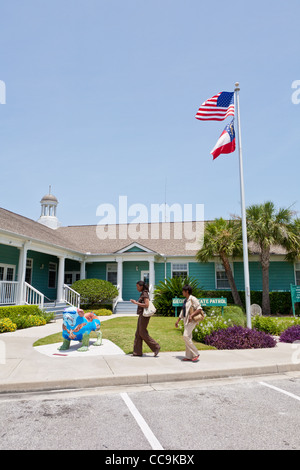 Due donne nere camminano davanti all'Essence of Jekyll Island, o Essie al Jekyll Island Visitor Center sull'Isola Jekyll, Georgia. Foto Stock