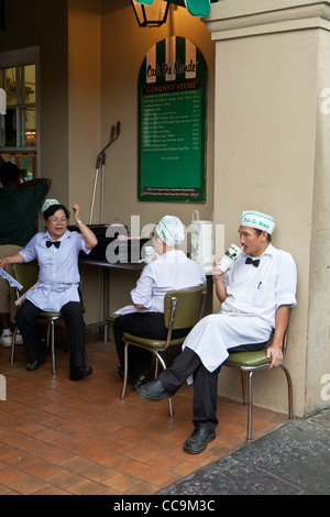 I dipendenti prendono una pausa dal servizio beignets e caffè presso il Cafe Du Monde nel Quartiere Francese di New Orleans, LA Foto Stock