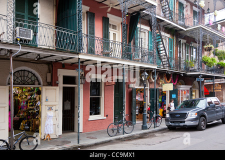 Edilizia residenziale con balconi al di sopra di una varietà di aziende nel Quartiere Francese di New Orleans, LA Foto Stock