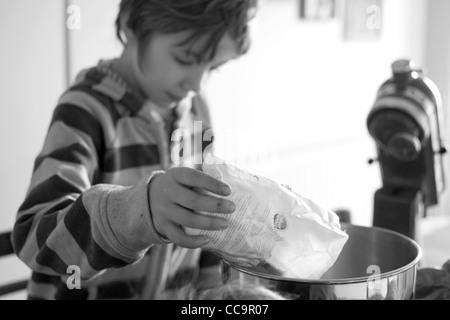 Ragazzo in cucina la cottura di una torta al cioccolato Foto Stock