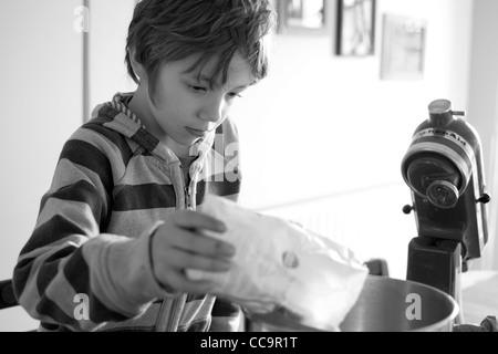 Ragazzo in cucina la cottura di una torta al cioccolato Foto Stock