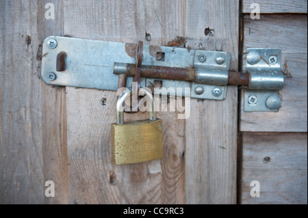 Bloccato il lucchetto in acciaio su una tettoia in legno Foto Stock