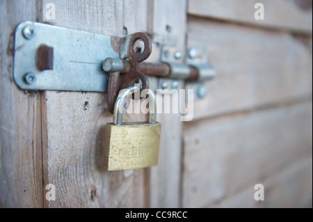 Bloccato il lucchetto in acciaio su una tettoia in legno Foto Stock