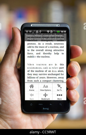 La lettura di un libro su Kindle app su un Android smartphone HTC Foto Stock