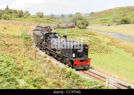 Una locomotiva a vapore sul Welsh Highland Line rendendo il suo modo di Porthmadog, avendo appena lasciato Waunfawr Foto Stock