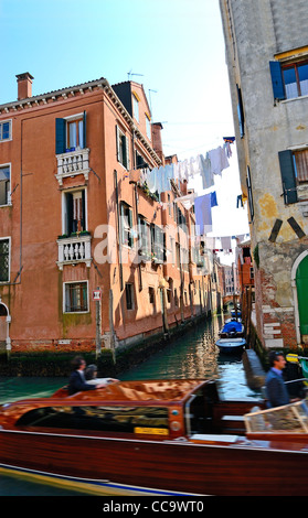 Foto a scatto lento dei turisti in taxi d'acqua che visitano i canali nord-orientali del Ghetto Ebraico, Venezia, Italia Foto Stock