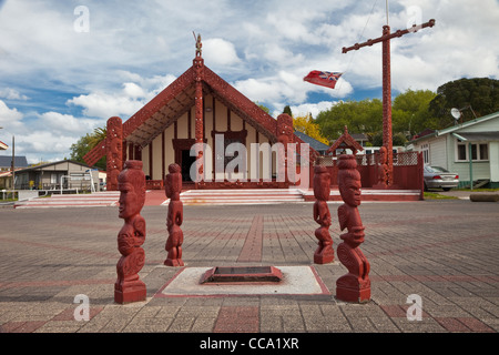 Rotorua. Ohinemutu Meeting House nel posteriore, Totem indicando quattro direzioni cardinali nella parte anteriore. Foto Stock