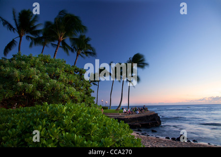 Gli ospiti godersi il tramonto a Lawai Beach, Po'IPU, Kauai, Hawaii. Foto Stock