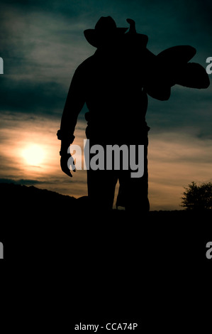 Uomo di lavoro silhouette al tramonto - cowboy si chiama un giorno Foto Stock