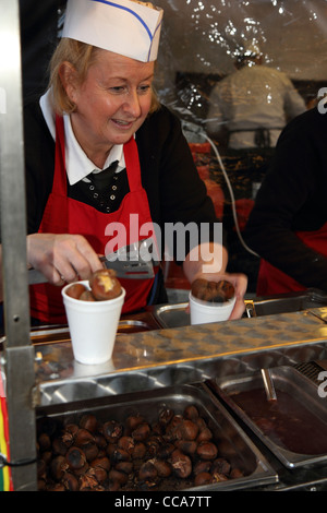 Donna che serve le castagne calde a Chatsworth mercatino di Natale Derbyshire Inghilterra Foto Stock