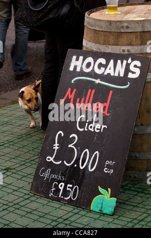 Piccolo Cane guardando il segno di vendita sidro mulled a Chatsworth mercatino di Natale Derbyshire Inghilterra Foto Stock