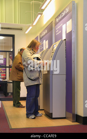 Persone prelevare denaro contante formano una macchina ATM in una Natwest Bank, Eastbourne, East Sussex, Inghilterra. Foto Stock