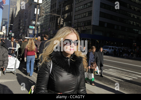 Attraente giovane donna camminare lungo la Quinta Avenue in New York City, Stati Uniti d'America, 13 dicembre 2011, © Katharine Andriotis Foto Stock