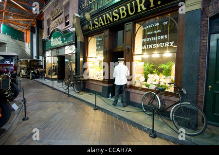 Un modello di un milkman che consegna il latte a un negozio di formaggi nella mock-up High Street al Beaulieu National Motor Museum nella New Forest dell'Hampshire Foto Stock