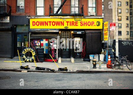 Taxi visto cambiare vi pneumatici a un pneumatico negozio di riparazione sulla 10th Avenue in New York City, Stati Uniti d'America. Foto Stock