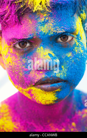 Giovane ragazzo indiano coperto di polvere colorata pigmento. India Foto Stock