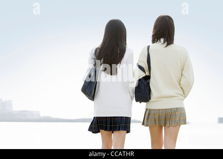 Due high school ragazze guardando l'oceano Foto Stock