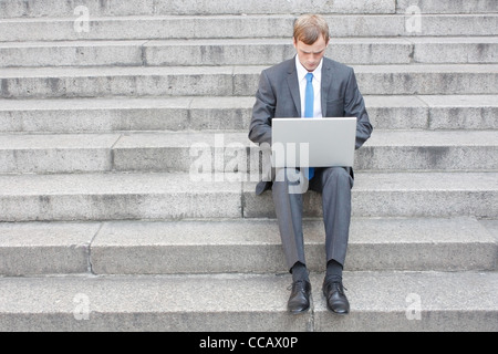 Business uomo seduto sulle scale per esterno Foto Stock