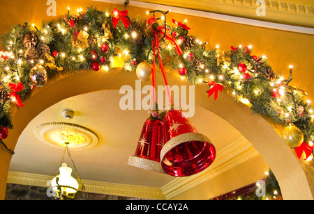 Campane e le luci fairy come parte delle decorazioni di Natale in un pub irlandese. Foto Stock