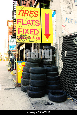 Taxi visto cambiare vi pneumatici a un pneumatico negozio di riparazione sulla 10th Avenue in New York City, Stati Uniti d'America. Foto Stock