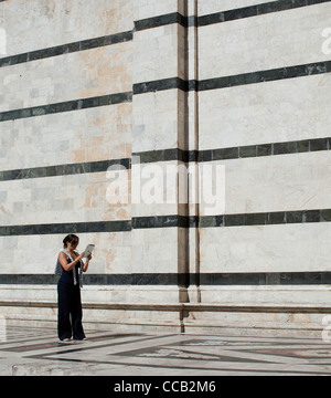 Una donna con il suo ipad Apple per scattare foto al di fuori della cattedrale, Siena. L'Italia. Foto Stock