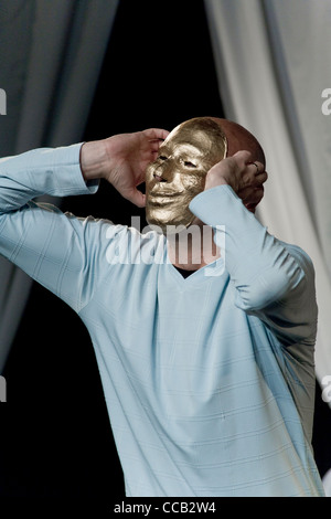 Un artista Mime sul palco in una maschera d'oro Foto Stock