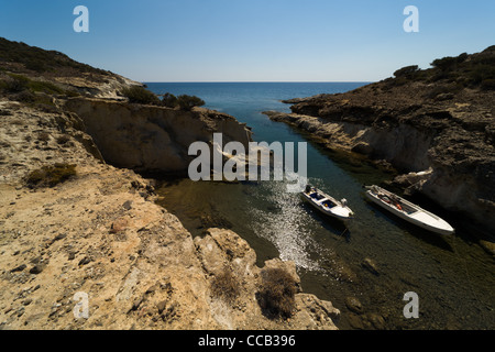 Barche a vuoto in attesa su una baia stretta in Isola di Milos, Grecia, CICLADI Foto Stock