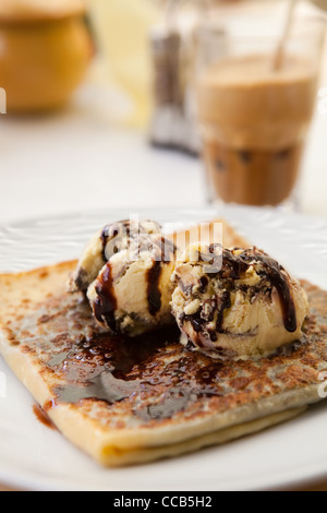 Deliziosi dolci crêpe con gelato e salsa al cioccolato Foto Stock