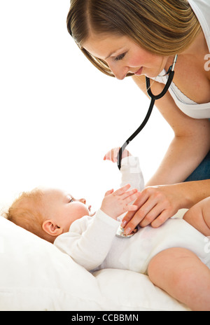 Madre ausculating infant Baby girl su bianco Foto Stock