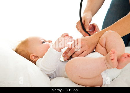 Madre ausculating infant Baby girl su bianco Foto Stock