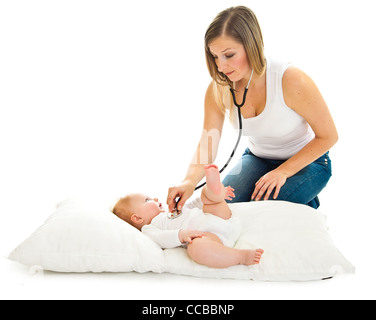 Madre ausculating infant Baby girl su bianco Foto Stock