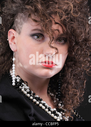 Ragazza - ear piercing super donna capelli scuri marrone naturale dai capelli sfondo nero Foto Stock