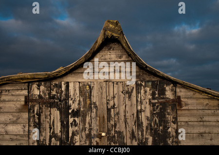 Capovolta la pesca di aringhe barca sull Isola Santa Lindisfarne, ora utilizzato come un capannone per il rimessaggio. Foto Stock