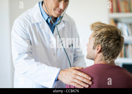 Medico utilizzando uno stetoscopio sul paziente Foto Stock