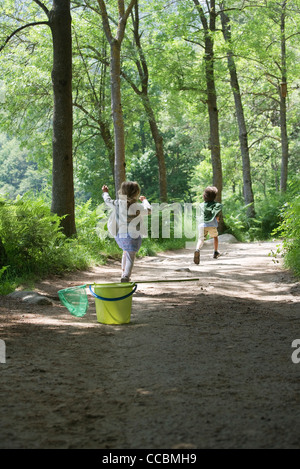 I bambini in esecuzione sul percorso attraverso i boschi Foto Stock