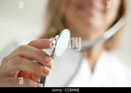 Medico tenendo fuori uno stetoscopio ritagliato Foto Stock