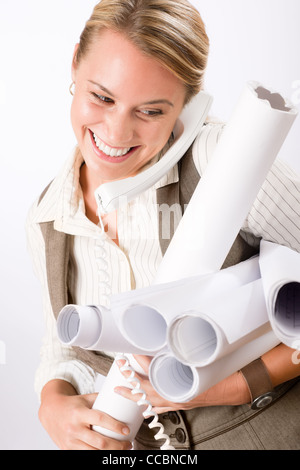 Sorridente femmina giovane architetto azienda blueprint isolati su sfondo bianco Foto Stock