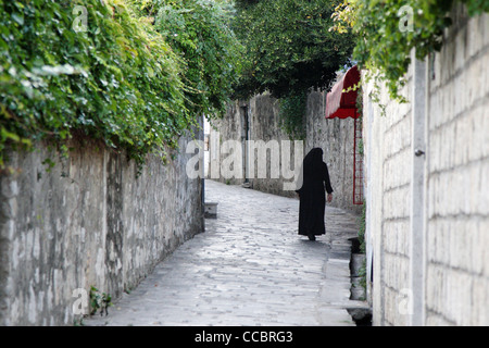 Nun a piedi verso il basso strada di ciottoli in Croazia. Foto Stock