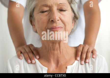 Senior donna ottenendo un massaggio della spalla Foto Stock