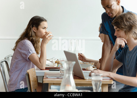 Amici nel ristorante, pranzo donna, uomo utilizzando il computer portatile