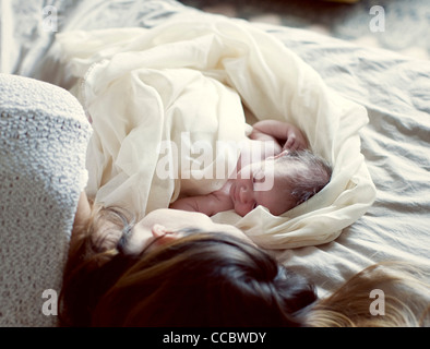 New Born Baby e madre in appoggio a letto Foto Stock