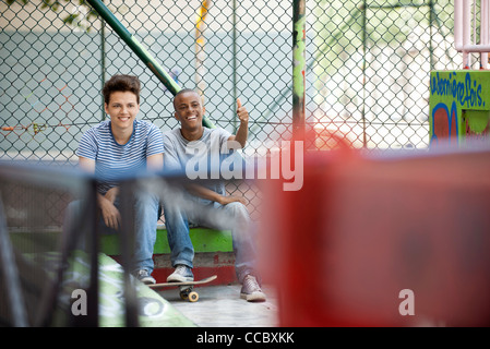 Giovani uomini appendere fuori a skate park Foto Stock