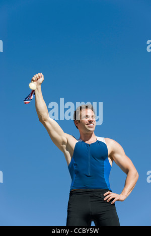 Atleta maschio mantenendo la medaglia d'oro Foto Stock