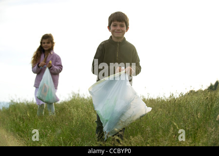 Bambini il prelievo del cestino nel campo Foto Stock