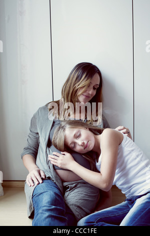Figlia ascolto a donne in stato di gravidanza della madre addome, ritratto Foto Stock