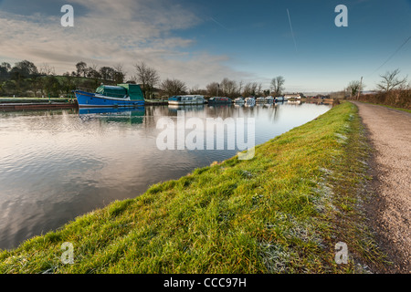 Barche su un canale con un freddo gelido alzaia e blu cielo nuvoloso Foto Stock