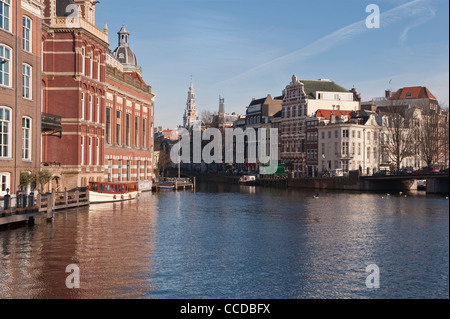 Il fiume Amstel nel cuore di Amsterdam, Paesi Bassi. La torre dello Zuiderkerk è visibile in lontananza Foto Stock